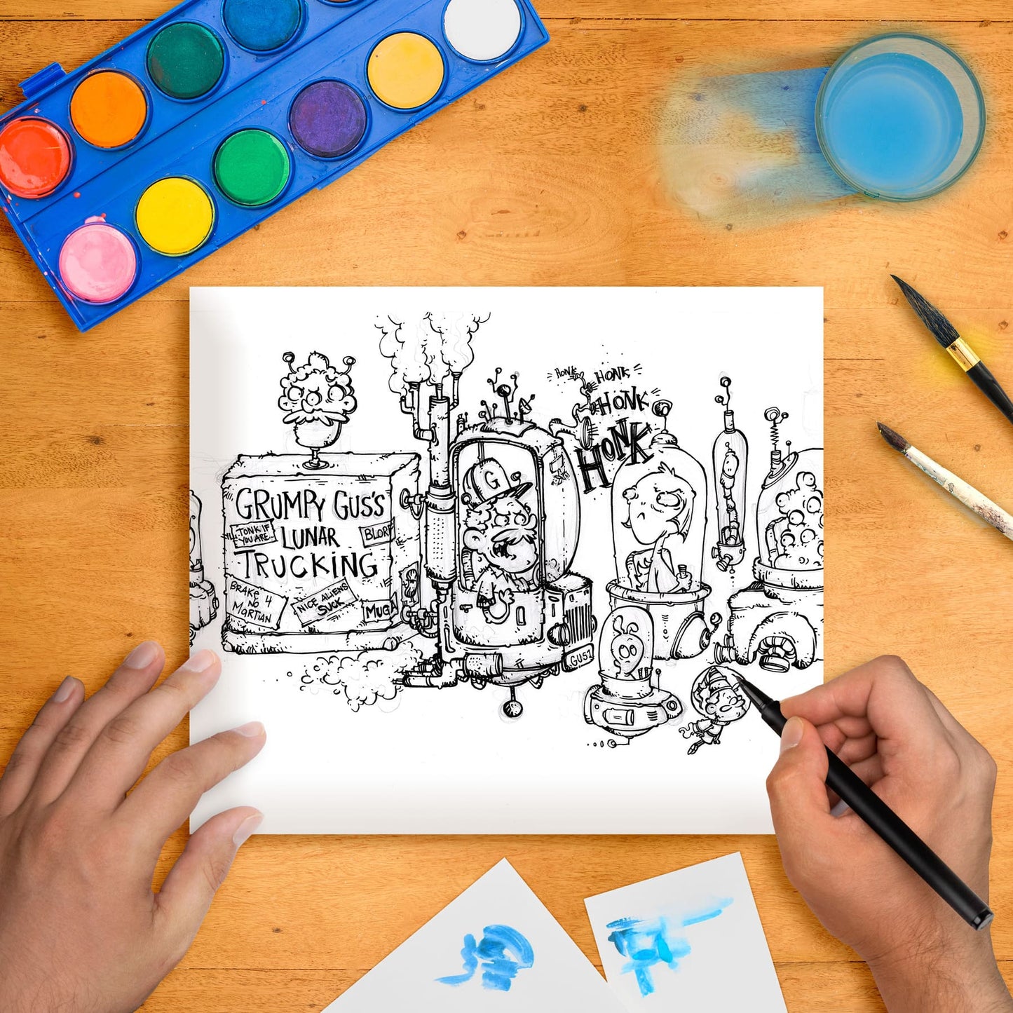 Original marker illustration artwork on paper, depicting a whimsical space trucking scene, laid flat on a wooden surface with art supplies around it.