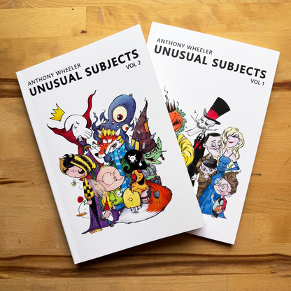 Anthony Wheeler’s Unusual Subjects Vol. 1 and Vol. 2 art books displayed together on a wooden tabletop.