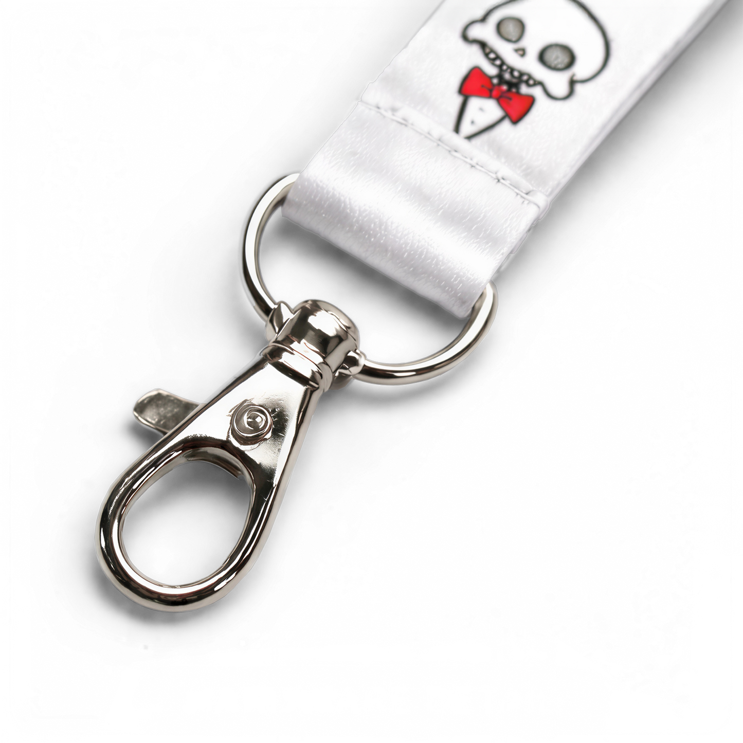Detail shot of the Chaotic Draw Along skull lanyard with white fabric, printed artwork, stitching, ring, and metal clasp.