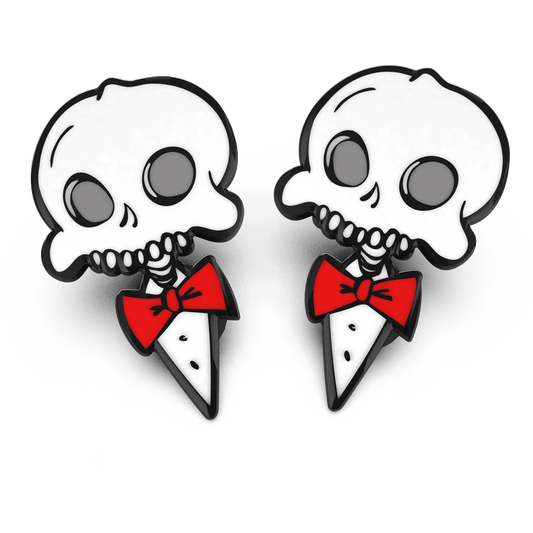 A pair of enamel pins featuring a stylized skull wearing a red bow tie and a black coat with a white collar.