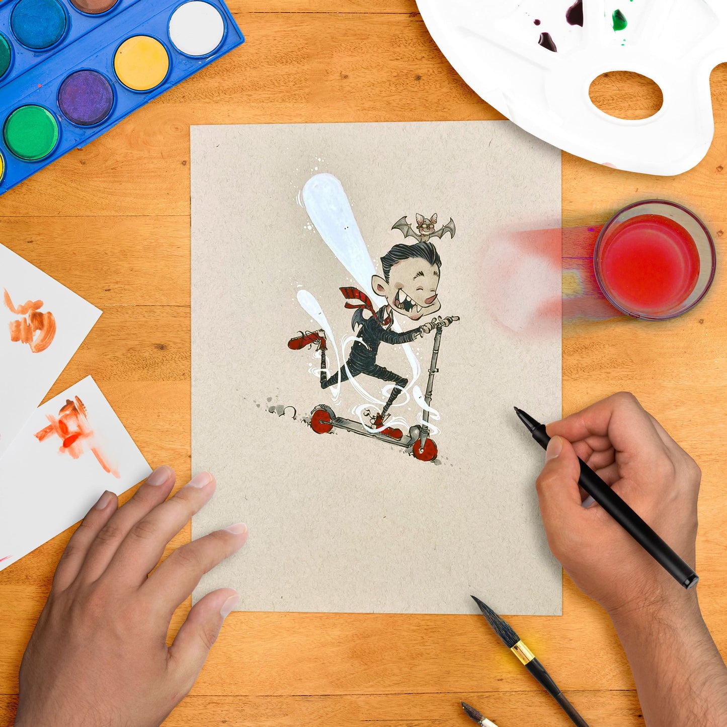 Original artwork depicting a stylized character riding a red and black toy cart, with an illustrator's hand drawing the image on paper.