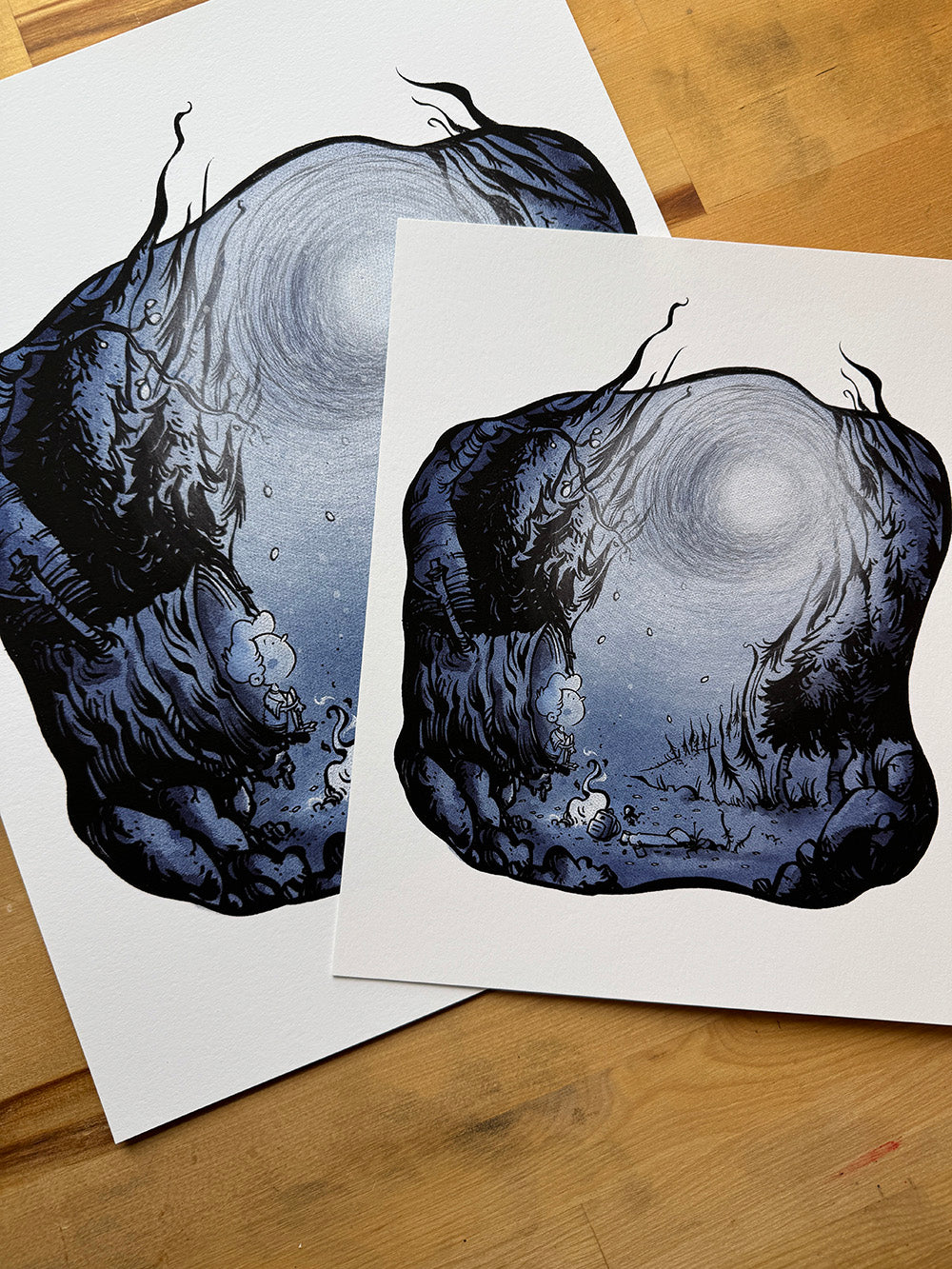 Two Lost in the Woods art prints displayed together showing size comparison on wooden desk.