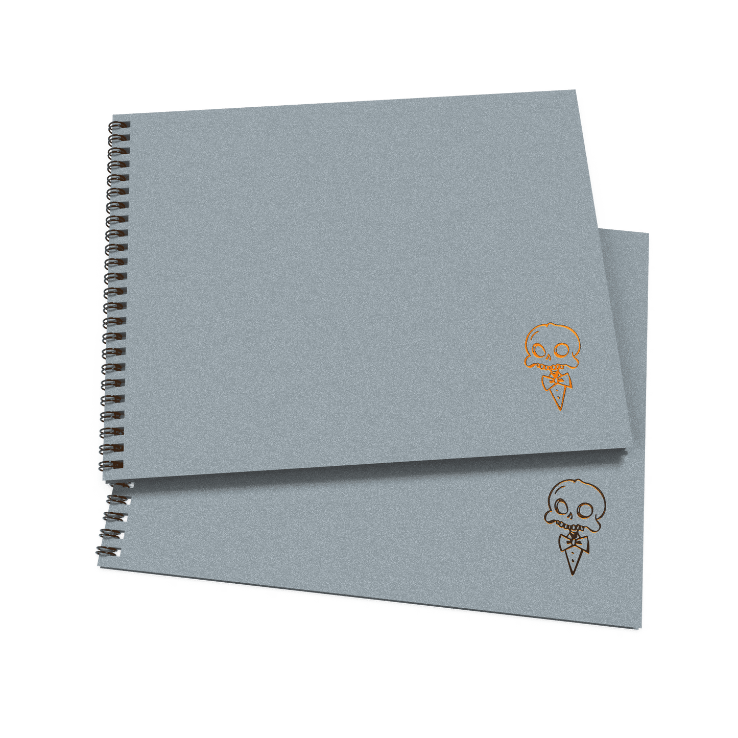 A stack of two gray sketchbooks with a decorative skull and crossbones design on the cover.