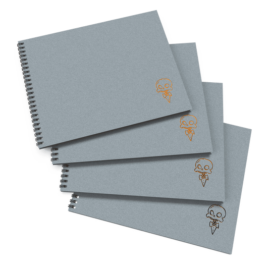 A stack of four gray sketchbooks with a decorative skull and crossbones design on the cover.