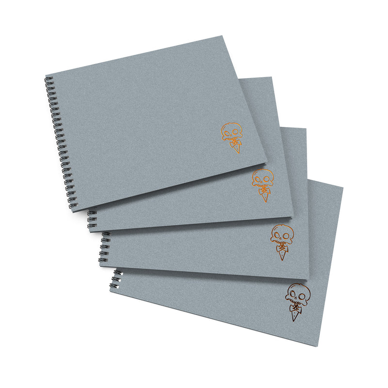 A stack of four gray sketchbooks with a decorative skull and crossbones design on the cover.